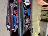a bag of tools sitting on the floor next to a pile of wood