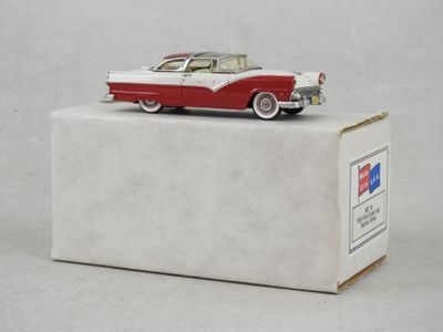 une maquette de voiture rouge et blanche posée sur une boîte