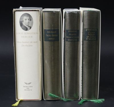 three books sitting on top of each other on a black surface