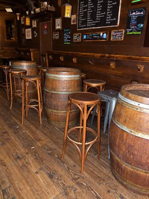 a wooden bar with a lot of stools and tables