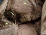 leather handbag with a metal buckle on the inside of it