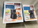two boxes of coffee machines sitting on a table