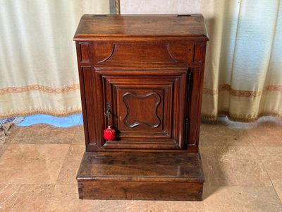 un petit meuble en bois surmonté d'une horloge