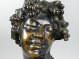 statue of a woman with a bunch of grapes on her head