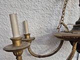 a chandelier hanging on the wall with two candles