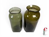 two green vases sitting next to each other on a white surface