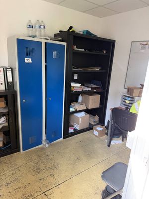 a blue locker in the corner of a room next to a desk