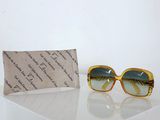 pair of yellow sunglasses sitting on top of a table next to a pouch