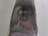 a spoon with a monogram on it sitting on a table