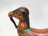 a wooden horse that is standing on a white surface