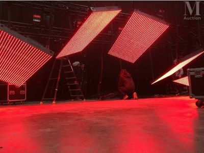 two people are standing on a stage with red lights