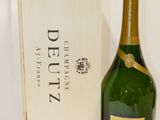 une bouteille de champagne et une boîte en bois posées sur une surface blanche