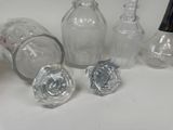 several glass bottles and a glass stopper on a table