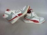 pair of white and red sneakers sitting on top of a white surface