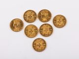 un groupe de cinq pièces d'or posées sur une surface blanche