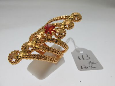 l'image d'une bague en or contenant une pierre rouge