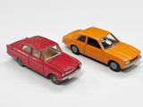 deux voitures jouets assises l'une à côté de l'autre sur une surface blanche