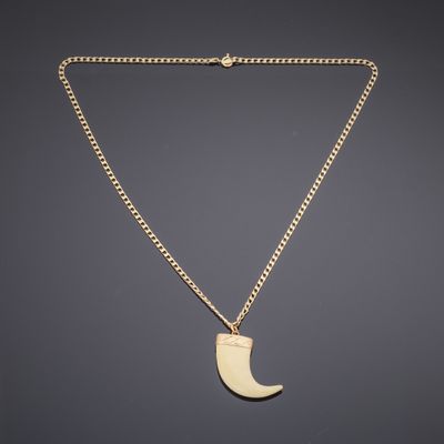 a gold necklace with a crescent pendant on a chain