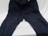black pants on a bed with a white sheet in the background