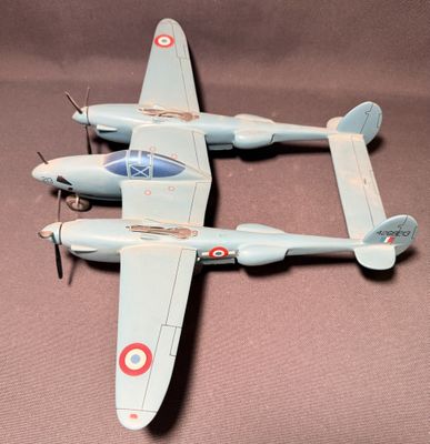 deux maquettes d'avion posées sur une table, sur un fond marron