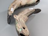 pair of carved wooden dolphins on a white surface