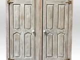 a pair of antique white painted wooden doors with brass hardware