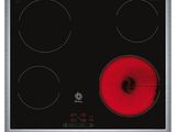 a close up of a black and red stove top with three burners
