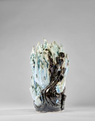 une sculpture représentant une personne assise sur un rocher