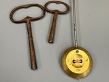 two old keys and a clock hanging on the wall