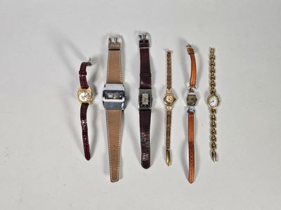 quatre types de montres sont alignés sur une surface blanche