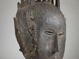 an image of a wooden mask with spikes sticking out of it ' s face