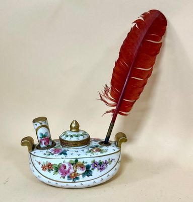 a feather quill sitting on top of a white bowl