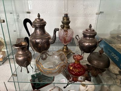 a glass display case with a variety of antique items on it