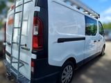 a white van parked in a parking lot with a ladder on the back