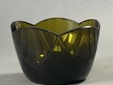 un bol en verre vert posé sur une table à côté d'une paire de ciseaux