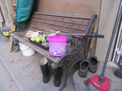 un banc en bois sur lequel est posé un seau de pommes