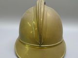 a gold helmet that is sitting on a white table