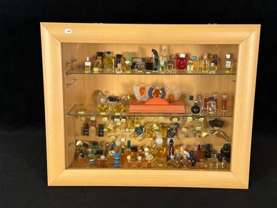 a wooden display case with a lot of perfumes in it