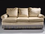 an image of a beige couch with pillows on it in a dark room