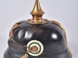 an old fashioned helmet with a brass top and a green and white stripe