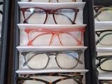 many pairs of glasses sitting in a display case