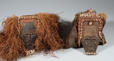 paire de masques africains aux cheveux longs sur fond gris