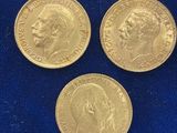 trois pièces « sovereign » en or posées sur un tissu bleu
