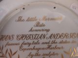 a white plate with gold writing on it that says the little mermaid