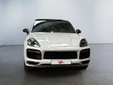 the white porsche cayen is parked in a large room