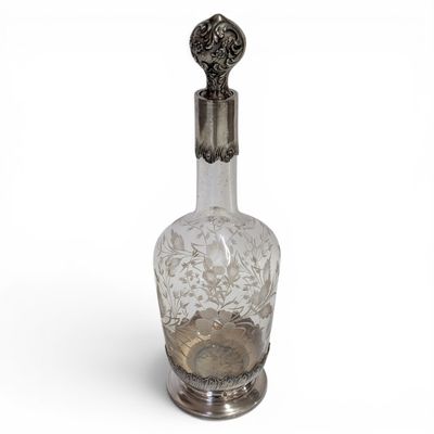 a glass bottle with a metal handle on a white surface