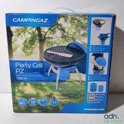 La boîte d'un barbecue Campingaz Party est ouverte sur la table.