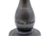 a black vase with writing on it sitting on a table