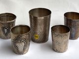 quatre coupes en argent ornées de motifs, posées sur une surface blanche