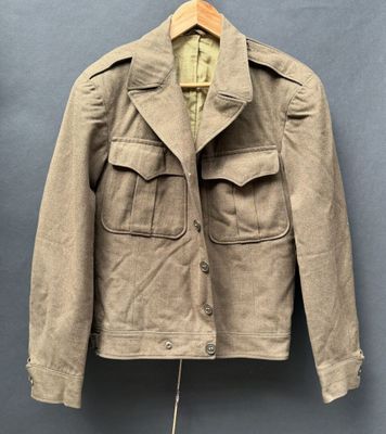 an old jacket hanging on a hanger on a wall